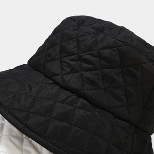 Close-up of black quilted bucket hat featuring diamond stitching and glossy nylon texture