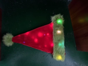 Close-up of a festive LED plush Christmas hat with red velvet and neon green faux fur detail