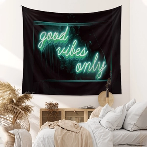 Detail of neon green good vibes only text on a black bohemian tapestry backdrop