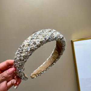 Detail of beige and gold tweed headband with sparkling sequins and premium velvet lining
