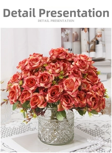 Detail showing artificial red silk roses in a textured glass vase on a lace tablecloth