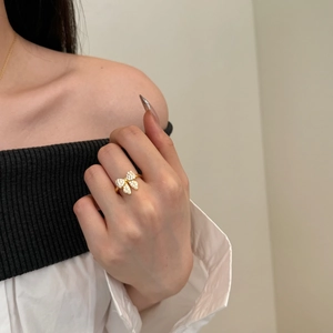 Close-up of elegant gold bow ring with zircon stones worn on a finger