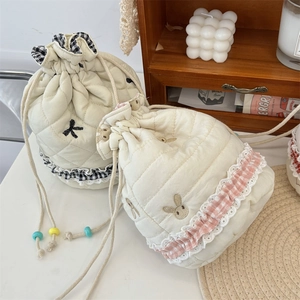 Quilted drawstring storage bag with cute rabbit embroidery and ruffled lace edge detail