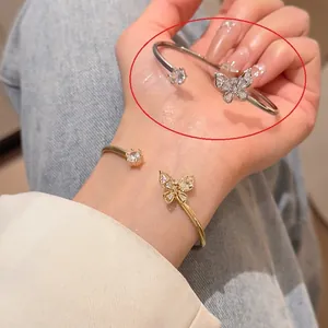 Détail d'un bracelet papillon ouvert avec zircons étincelants et une pierre ronde