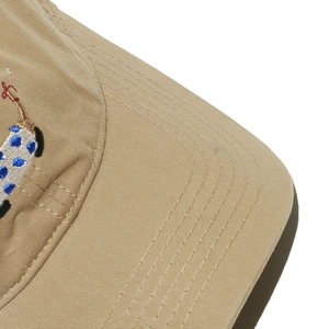 Detail of khaki cotton baseball cap showing blue polka dot embroidery and precision stitching