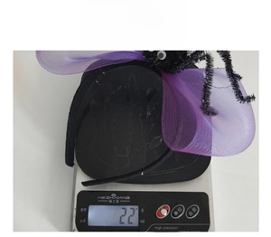 Detailed view of lightweight 22g Halloween spider headband on a digital scale