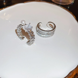 Detailed close-up of a silver-plated double-layer ring with square zircon and pearl inlay