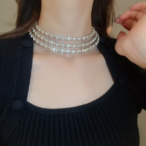 Close-up of triple-layered silver choker necklace with sparkling crystals on a model
