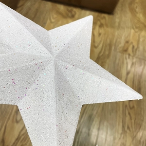 Macro view of a white Christmas tree star topper with sparkling glitter and matte texture