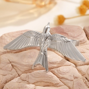Detailed view of bird-shaped silver earring showing intricate wing feather textures