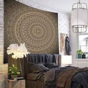 Detailed texture of the vintage gold and brown mandala tapestry hanging in a bedroom