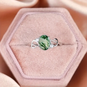 Macro shot of a silver moss agate ring with heart filigree in a pink velvet jewelry box