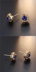 Close-up of gold round stud earrings with blue center stone and white zircon halo detail