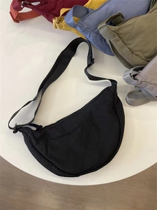 Flat lay display of nylon dumpling crossbody bags in diverse colors and textures