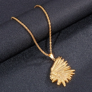 Detail of golden Indian chief pendant with intricate feathers on a twisted rope chain