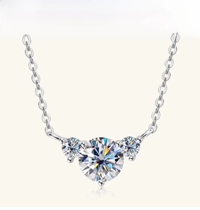Detail view of heart moissanite pendant with three-stone setting on silver O-chain