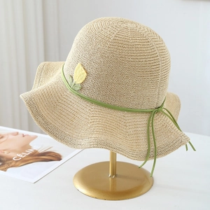 Detail of straw hat featuring yellow tulip embroidery and a green ribbon bow accent