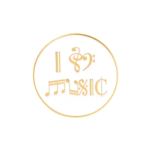 Détail de la broche ronde en émail musique avec cadre doré, notes et lettrage MUSIC