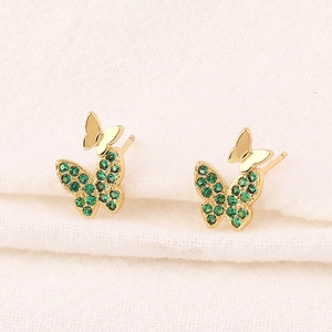 Close-up of gold butterfly earrings featuring sparkling green emerald-colored zircon stones