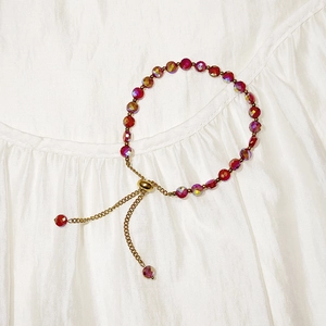 Detail of red faceted crystal beads and adjustable gold slider chain for women