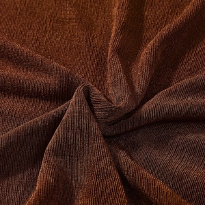 Vista macro della trama del tessuto plissettato bronzo metallizzato sull'abito