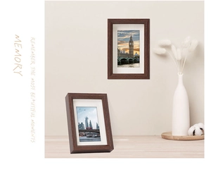 Detail of dark walnut wood picture frames shown in wall-mounted and standing desk displays