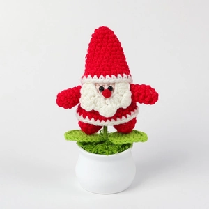 Dettaglio della trama in maglia di Babbo Natale all'uncinetto in un vaso di ceramica bianca
