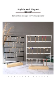Detail of multi-tier metal earring display stand with wooden base in black and white