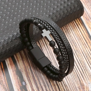 Detail of multi-layer braided leather bracelet with black beads and a metal cross charm