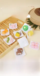Detailed macro view of miniature resin dessert models in square white bowls