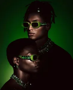 Detail of green gemstone-encrusted temple on chic rectangular sunglasses with matching jewelry