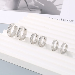 Detailed view of three sizes of silver-tone stainless steel hoop earrings with inset zircons