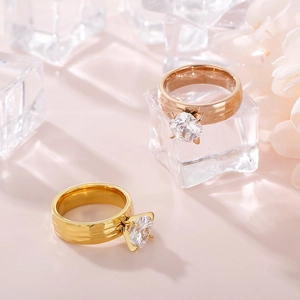 Close-up of hammered 6mm band rings with four-prong zircon stones on ice and flowers