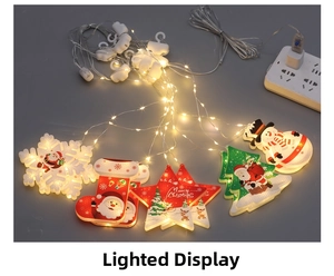 Detail of Christmas LED string lights with warm glowing Santa and snowflake pendants