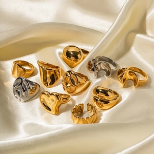 Detailed view of luxury gold and silver 18K gold-plated stainless steel rings on silk