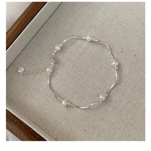 Detail view of S925 silver bracelet featuring freshwater pearls and heart charm