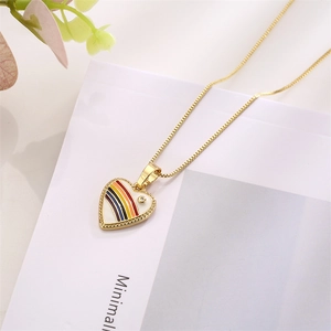 Macro view of gold heart pendant with rainbow enamel stripes and single diamond detail
