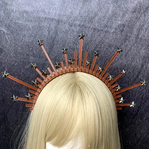 Detailed view of sun goddess halo headband with silver stars on golden blonde hair