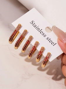 Macro view of 18k gold plated U-shaped hoop earrings with red gradient zirconia inlay