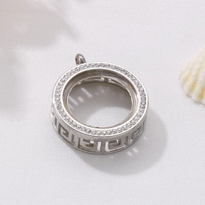 Detail of silver round pendant with cubic zirconia stones and geometric hollow pattern
