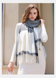 Close-up of black, white and grey plaid scarf with soft tassels and warm texture