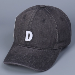 Detailed view of dark grey washed denim baseball cap with white embroidered letter D