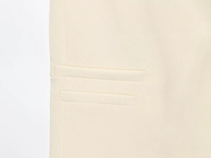 Gros plan sur un tissu tissé blanc cassé montrant des détails de couture précis