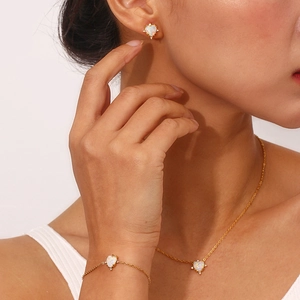 Close-up of gold-plated heart-shaped opal jewelry set featuring iridescent rainbow luster