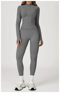 Détail d'un ensemble de yoga gris avec veste zippée, legging taille haute et passe-pouces
