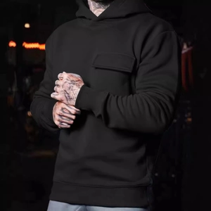 Detail of black hoodie featuring a functional chest flap pocket and soft cotton texture