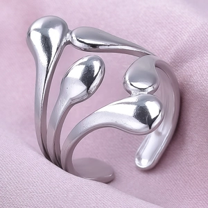 Macro shot of silver liquid metal wrap ring with teardrop ends on pink fabric