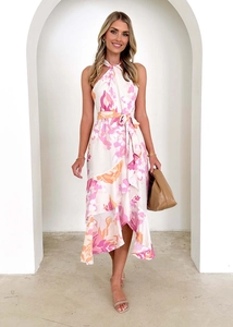 Détail d'une robe fleurie rose à col licou avec ceinture et ourlet à volants