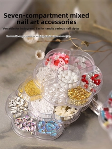 Macro shot of assorted nail art charms including pearls and rhinestones in flower case