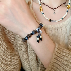 Detail of acrylic coffee bean bead bracelet with Fu character tag and colorful tassels